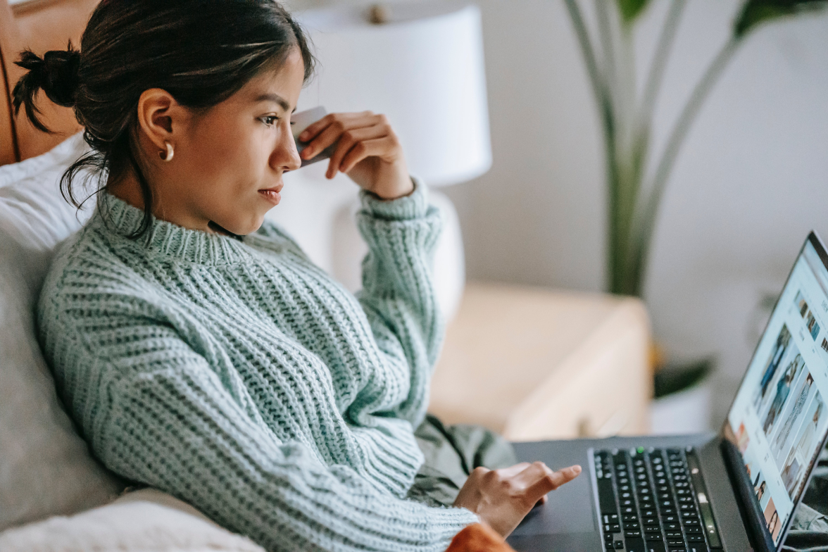 Person on the couch browsing her laptop