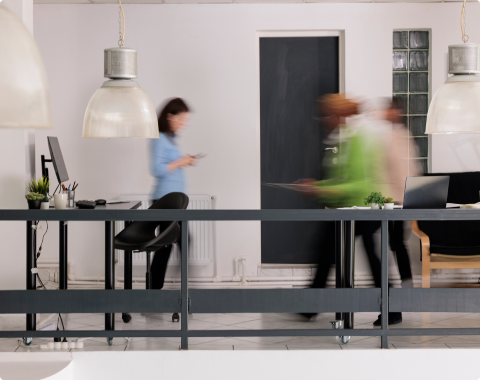 Well lit office space with 3 individuals in a blurred motion